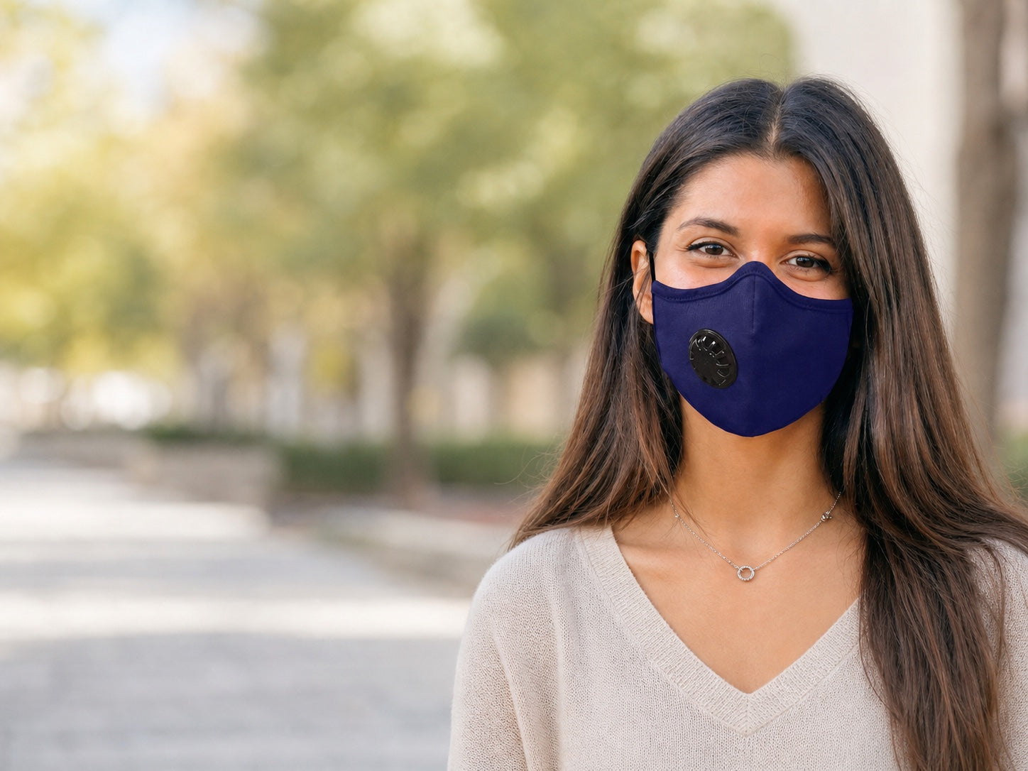 Woman wearing an indigo OxiClear valved pollution mask