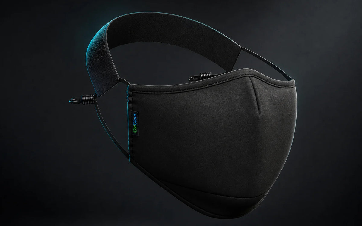Black OxiClear N99 mask without a valve showing its smooth front, adjustable side cords, and detachable headband